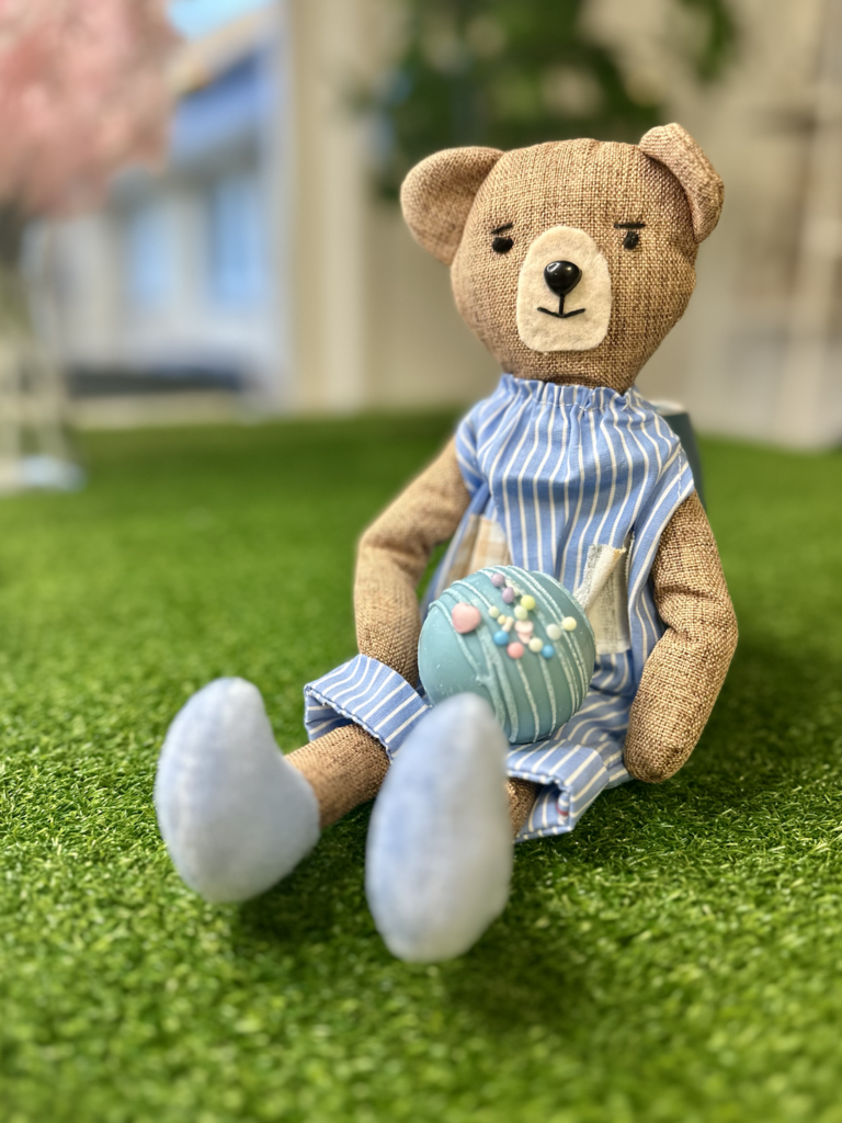 Trøstebamse med sut på skødet som hjælp til trygt suttestop for børn